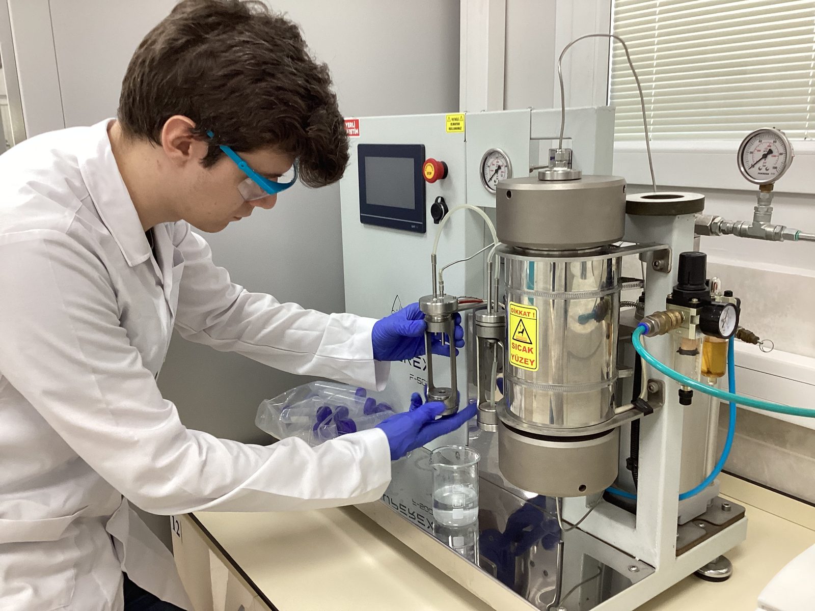 Operator loading a lab-scale supercritical CO2 extraction unit